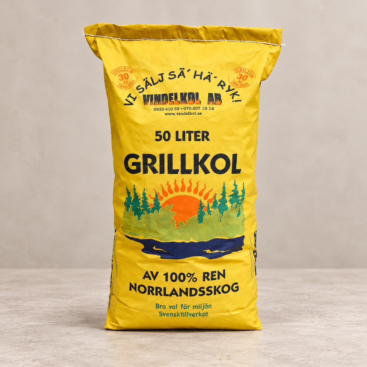 Vindelkol Grillkol 50 liter, gul säck på varm ljus stenbakgrund